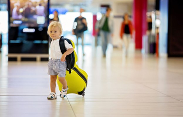 Bub mit Handgepäck am Flughafen