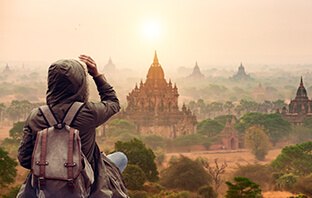 Frau steht an einem Aussichtspunkt und blickt auf die historischen Pagoden