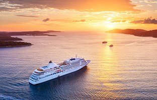 Ein Kreuzfahrtschiff fährt in den Sonnenuntergang