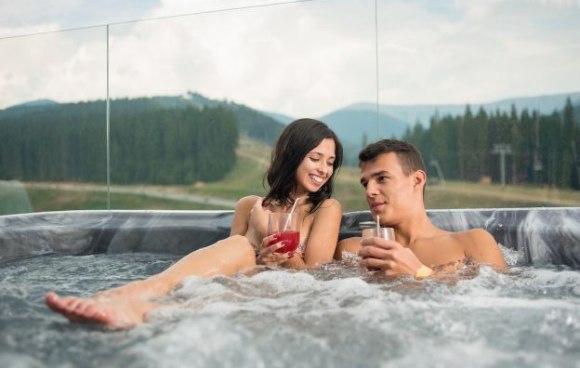 Paar sitzt in Whirlpool bei einem Thermenurlaub