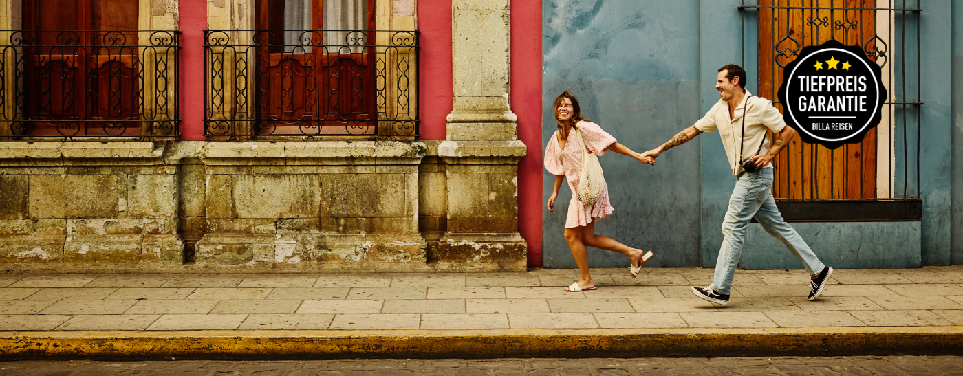 Paar steht mit Kamera und Strohhüten in einer antiken Sehenswürdigkeit und genießt die Rundreise