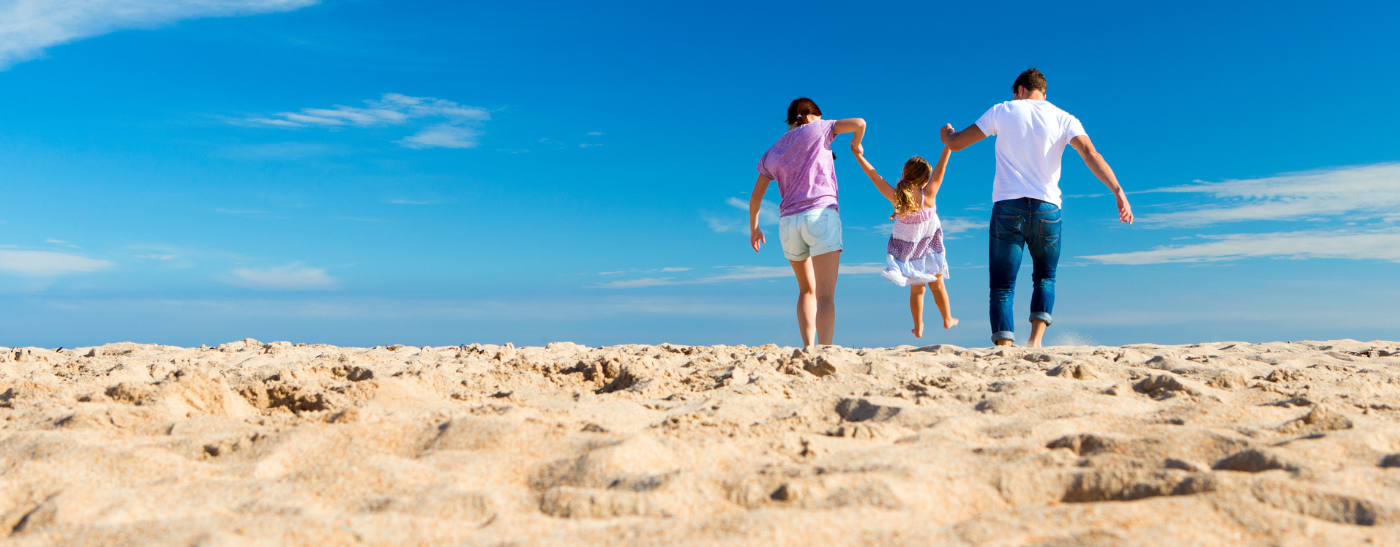 Eltern am Strand spielen mit ihrem Kind