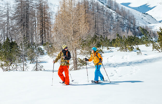 Zwei Menschen beim Schneeschuhwandern in den verschneiten Bergen