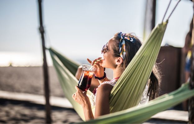 Frau liegt in der Hängematte und genießt ihren Winterurlaub
