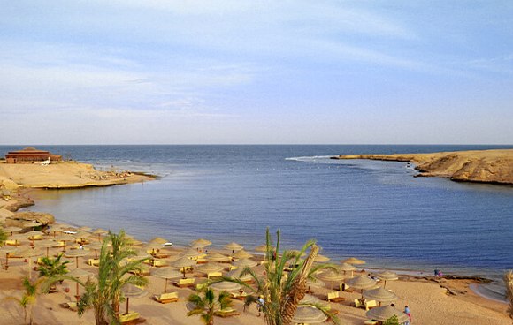 Strand, Meer, Sonenschirme aus Stroh und Palmen in Ägypten, rotes Meer