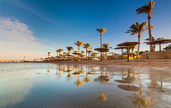 Strand, Meer, Sonenschirme aus Stroh und Palmen in Ägypten, rotes Meer