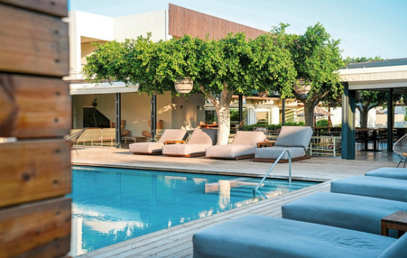 Poolansicht eines modernen Hotels mit stylischen Liegen