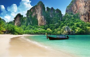 Ein Strand bei Thailand mit einem traditionellem Schifferboot