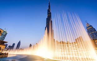 Das Burj Khalifa in der Abenddämmerung mit einer Brunnen und Lichtshow