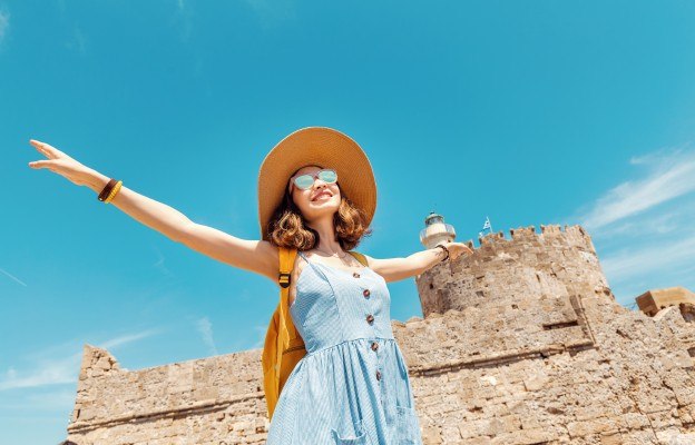Frau genießt die Sonne und die Sehenswürdigkeiten bei einem Last Minute Griechenland Urlaub