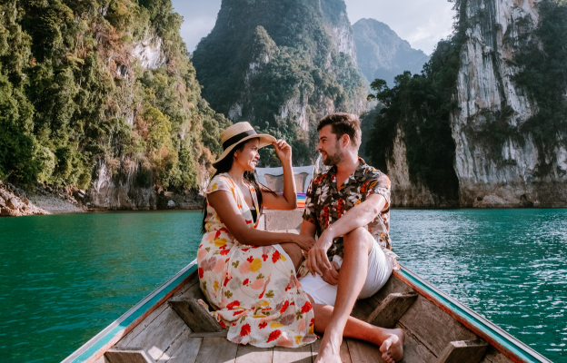 Paar sitzt auf einem Boot im Last Minute Thailand Urlaub