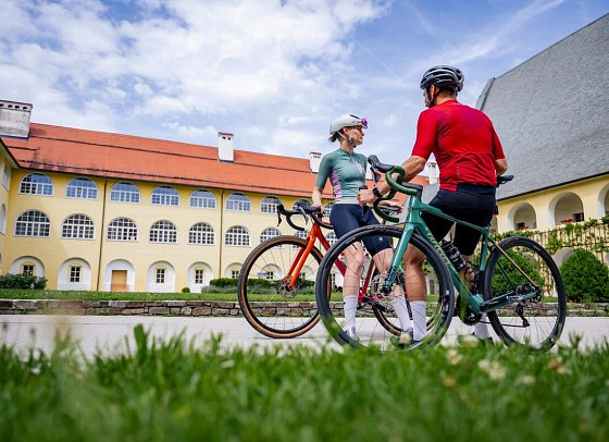 Stift St. Georgen - Paar mit Fahrrädern vor dem Stift