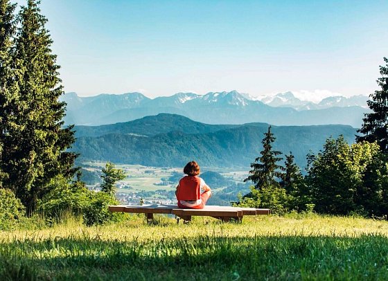 Stift St. Georgen - Frau auf Bank mit Blick auf den Kitzelberg